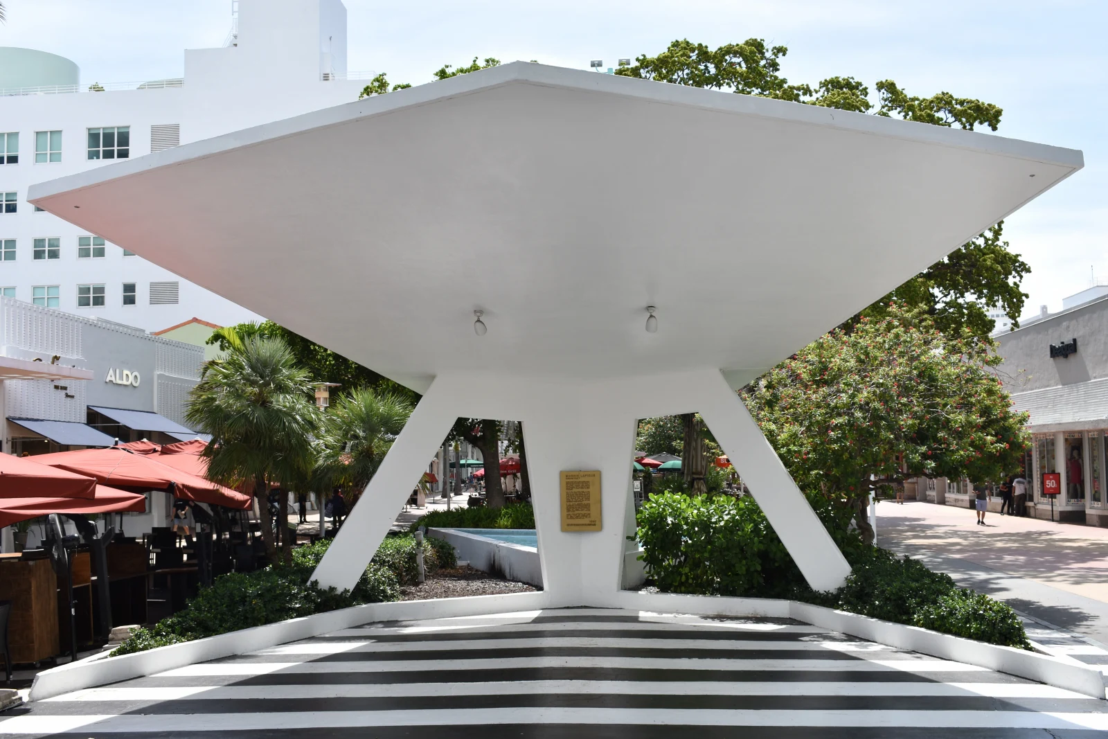 Morris Lapidus’s angular white shade canopy, splayed supports and black-and-white striped paving on Lincoln Road, photographed in color in 2019.